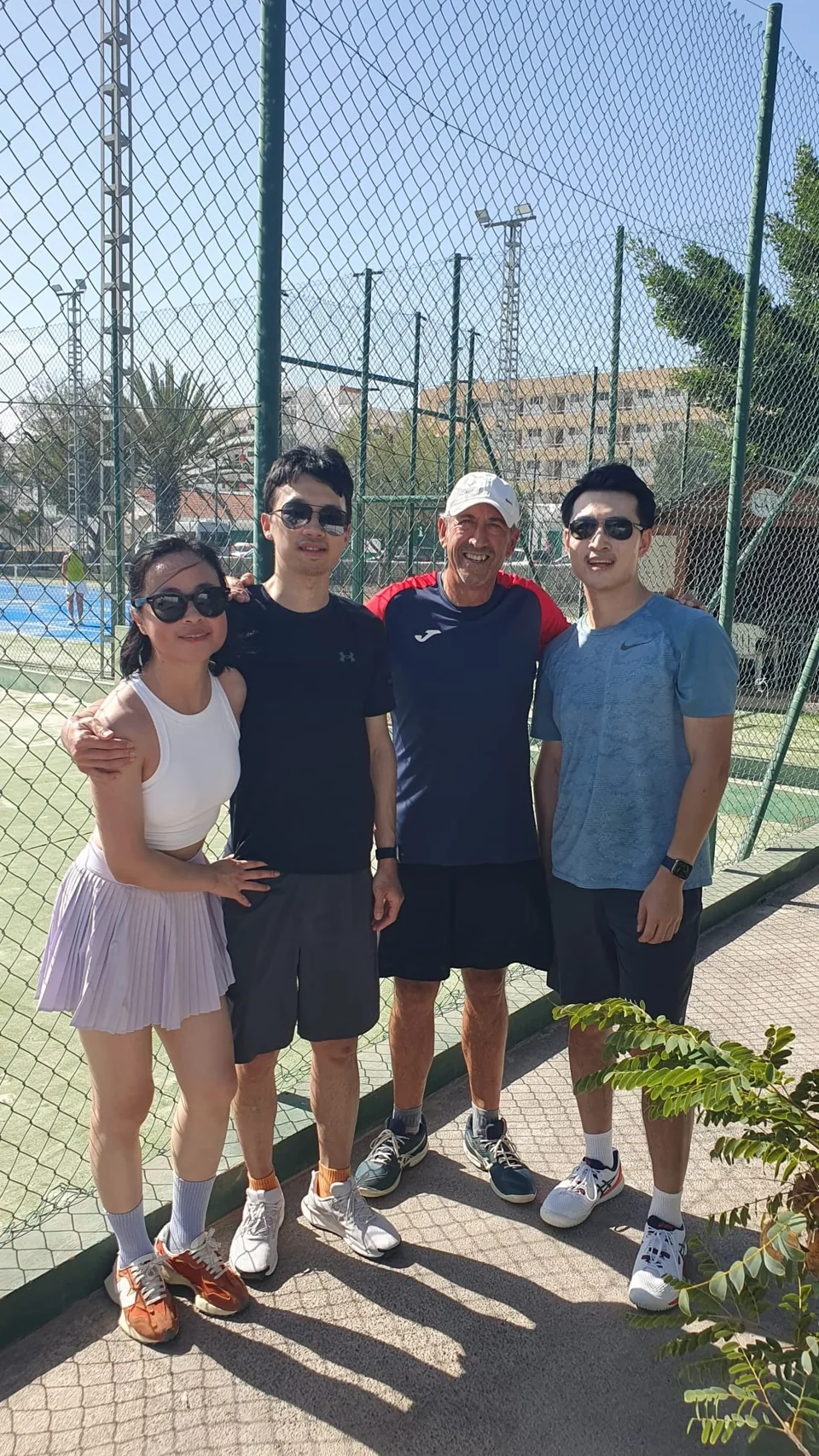 Juan with three players beside the tennis courts