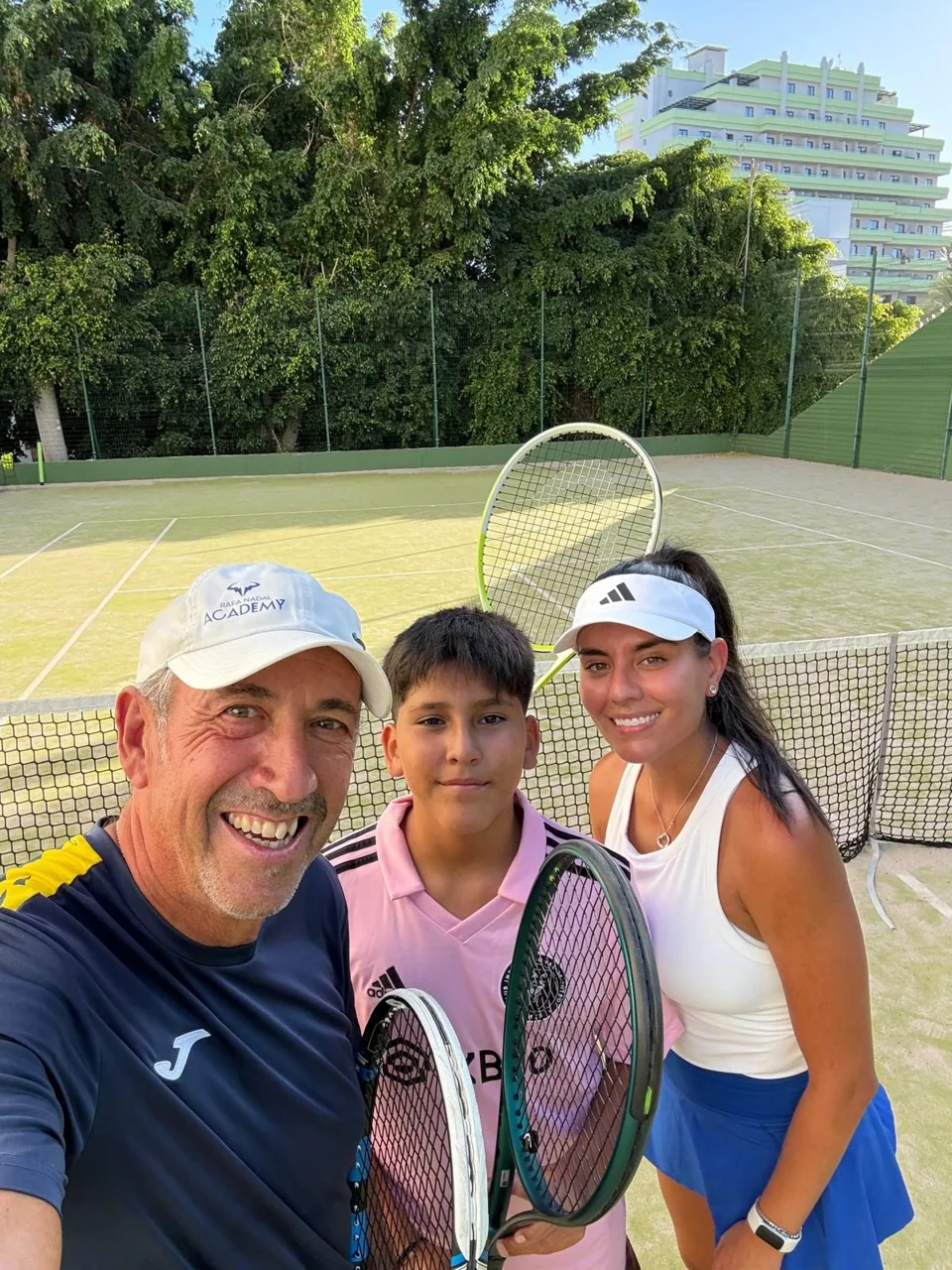 Juan with two students in a photograph by the net