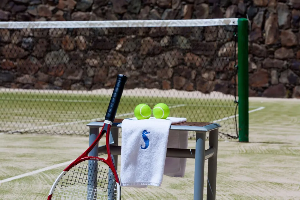 Net, racket and balls on the Hotel Sandy Beach tennis court